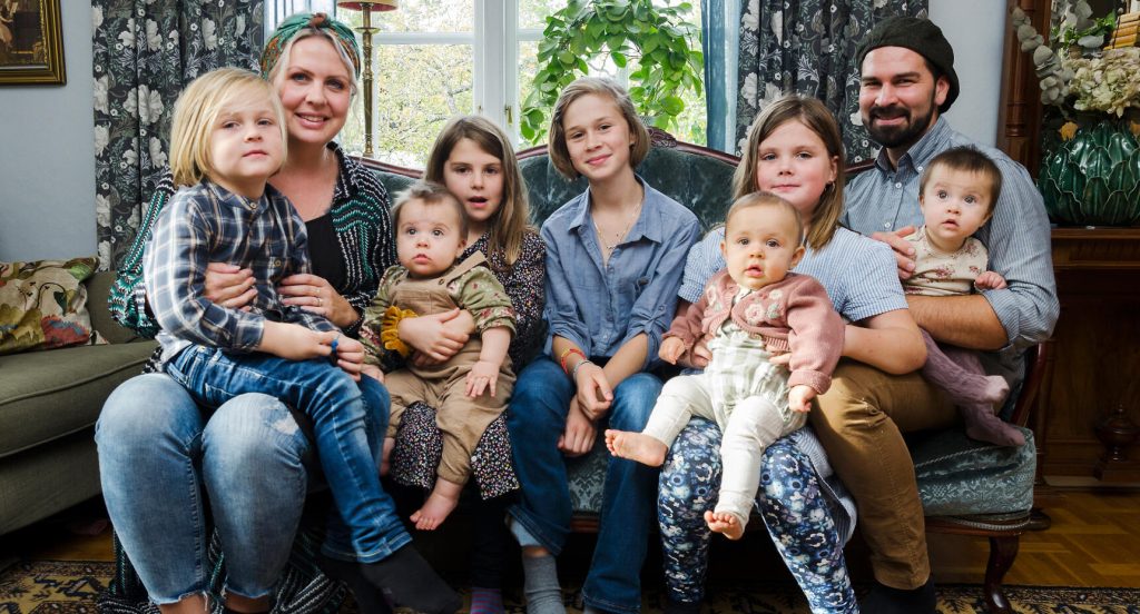 Hela familjen samlad på en bild: mamma Sofia med Elis i knät, Märtha med Aina, Judith, Signe med Ines och pappa Sebastian med Margit.