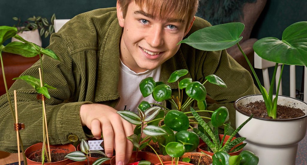 Malte, omgiven av krukväxter. Han pekar på skvallerrevan, som tack och lov bara blir vackrare ju fler sticklingar man tar.