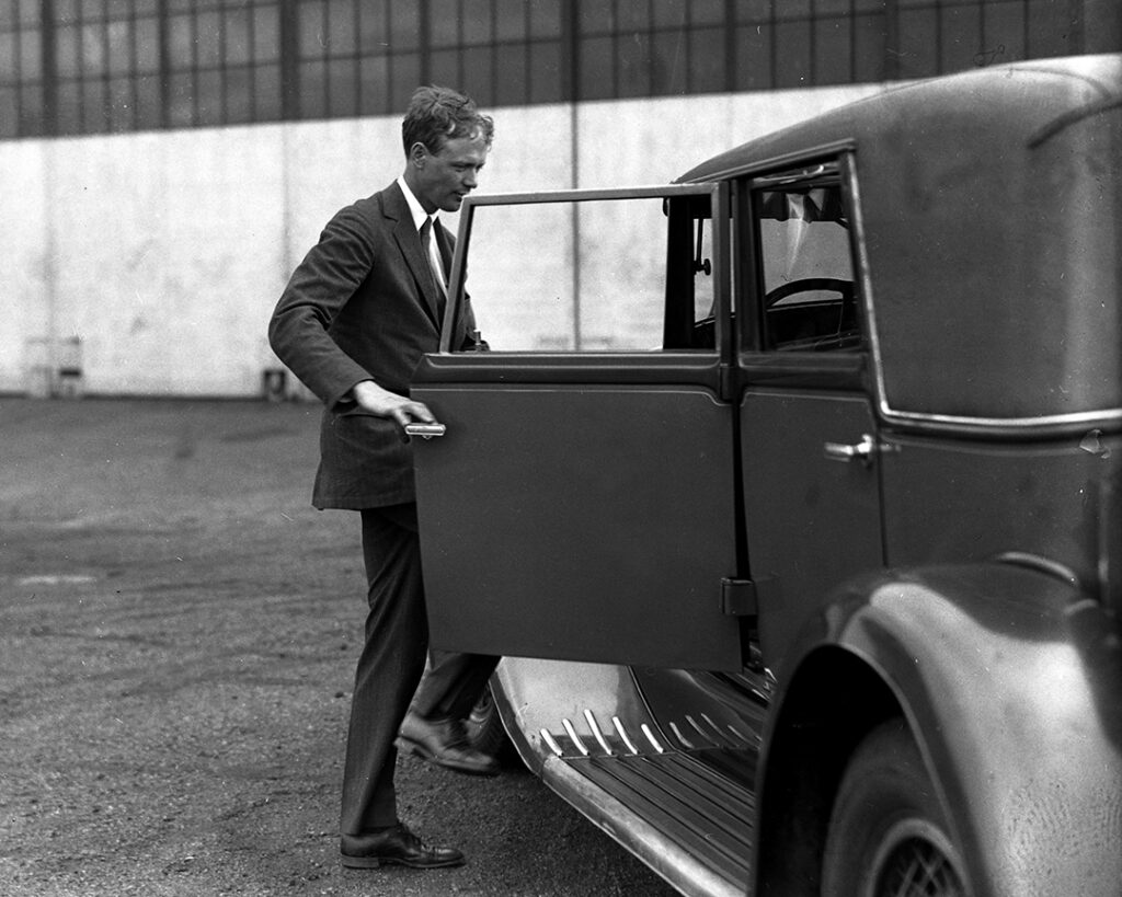 Svart-vitt foto av Charles Lindbergh som kliver in i en bil.