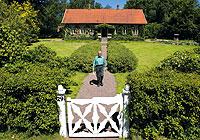 Prydlig grusgång och gräsmatta möter besökaren på Olinelund. Bakom huset börjar djungeln.Alla fotografier: Magnus Trole