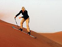 Snowboard blir sandboard. Att kana bräda nedför en sandkulle är ett stort turistnöje i Dubai.Foto: Johan Almblad