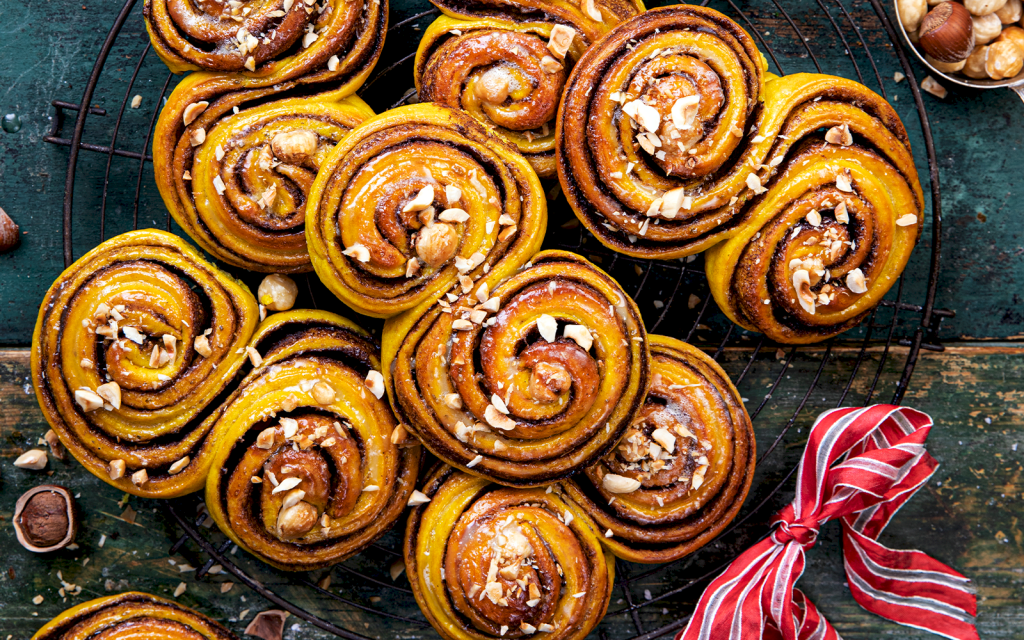 Lussebullar med nötkräm med garnering av hackade hasselnötskärnor.