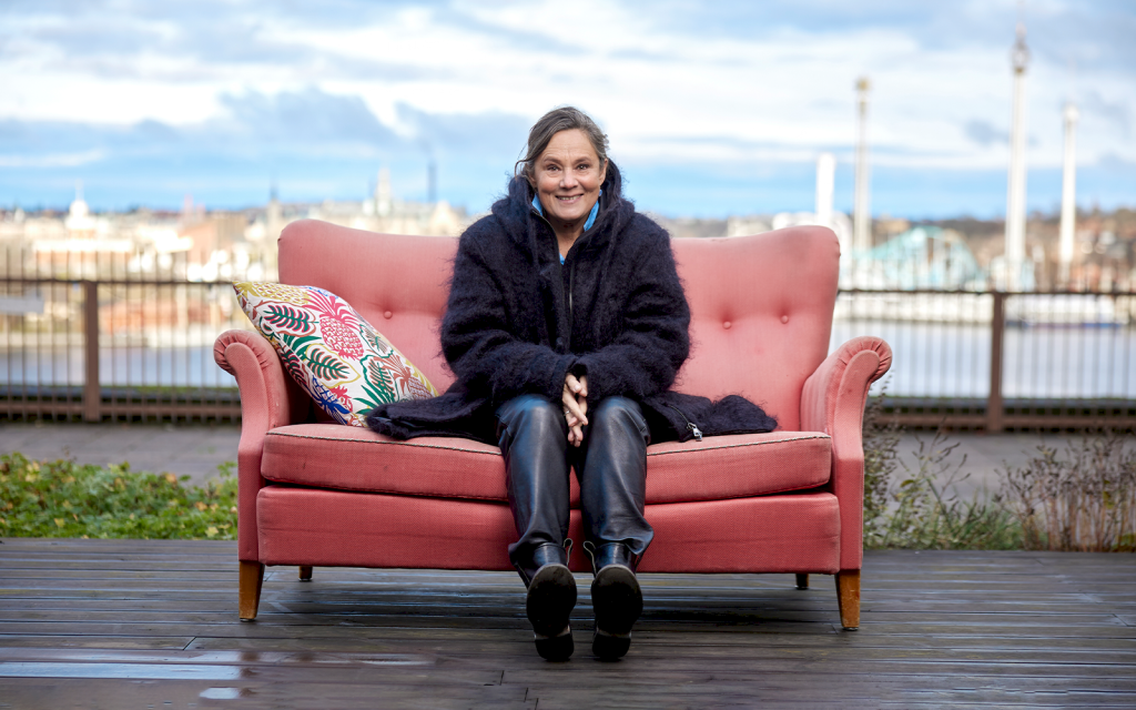 Pernilla august på rosa soffa vid Mosebacke, södra teatern, med Gröna Lund i bakgrunden.