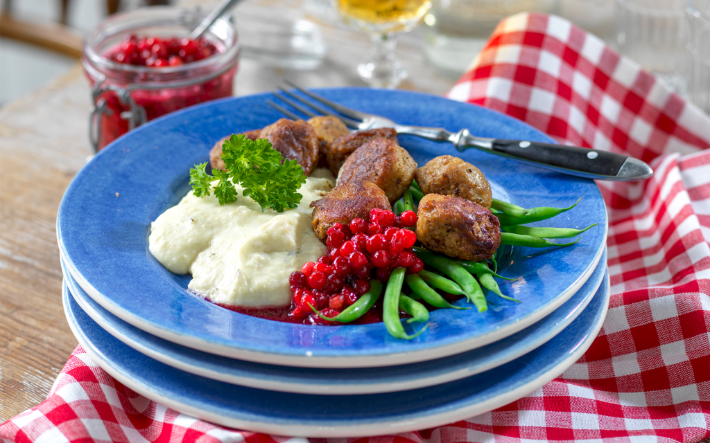 Rostat potatismos med selleri serverat med köttbullar, rårörda lingon och haricots verts.